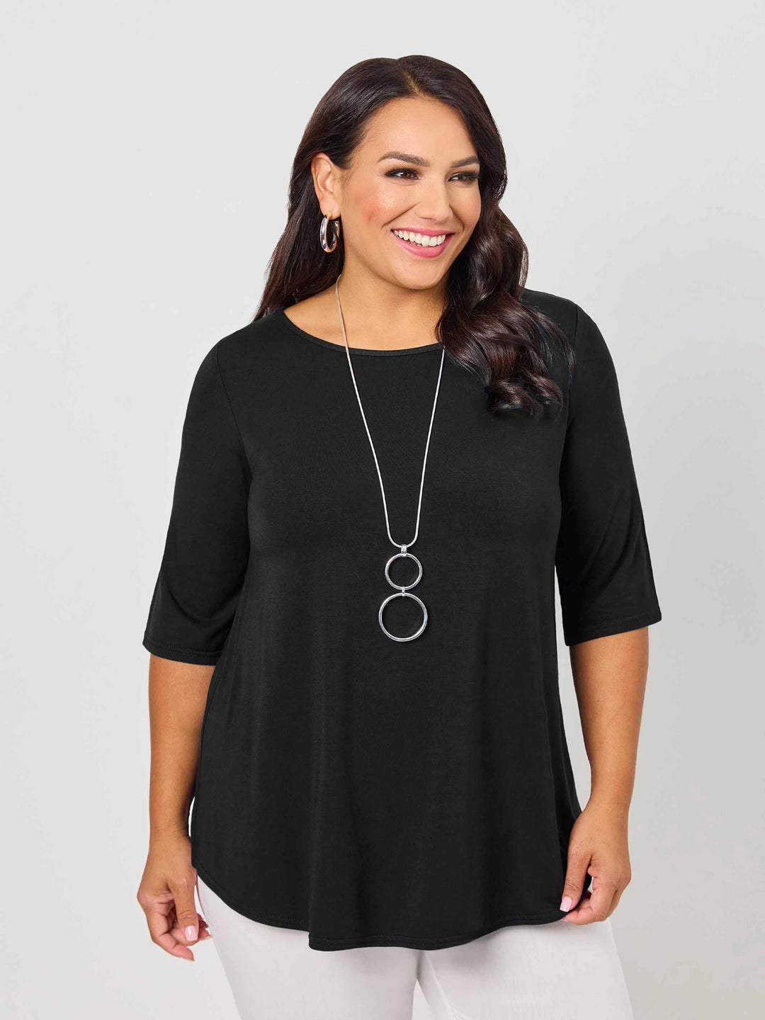 A woman modeling a black 3/4-sleeve top with a relaxed, flowy silhouette