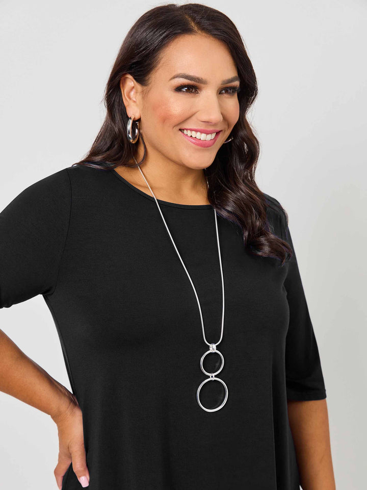 A close-up view of a woman wearing a classic black short-sleeve tee top