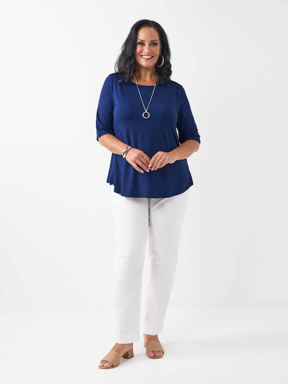 A woman modeling a navy blue three-quarter sleeve top and white pants