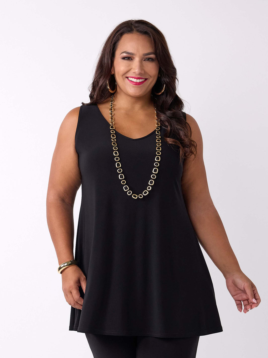 A woman modeling a sleeveless black tunic cami  top with a wide v-neckline