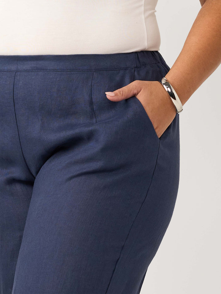 Close-up of a woman wearing navy blue tailored linen pant with a side pocket