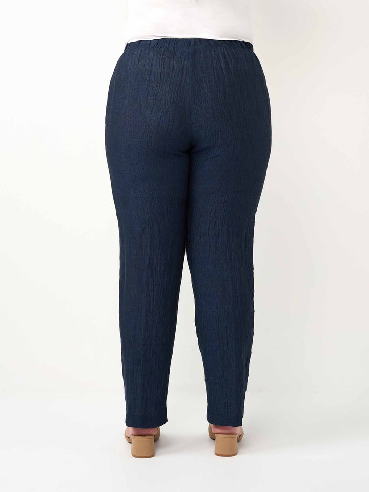 A person shown from the back wearing dark navy textured pants 