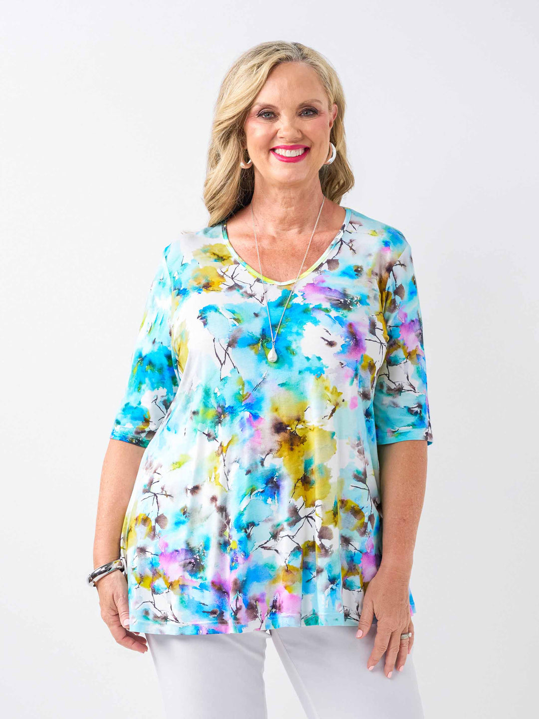 A woman wearing a short-sleeve jersey top with a vibrant blue watercolour floral print