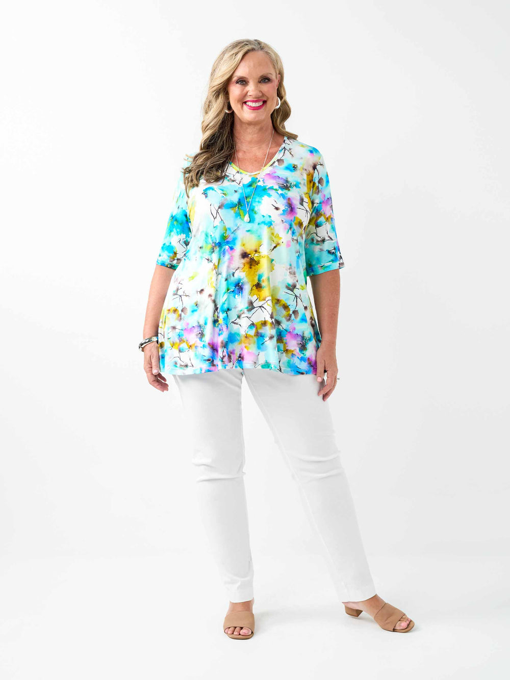 A woman wearing a short-sleeve jersey top with a vibrant blue watercolour floral print