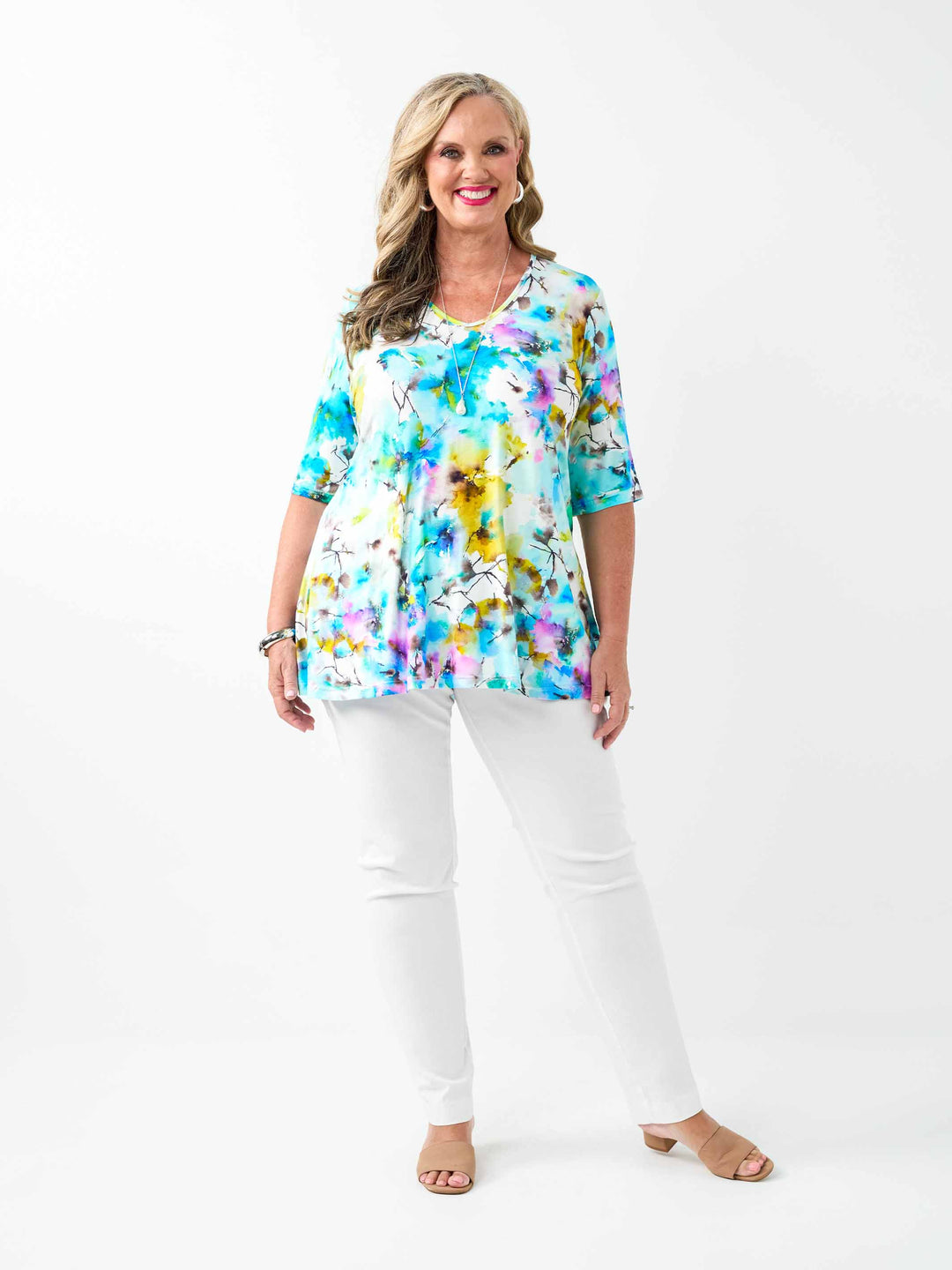 A woman wearing a short-sleeve jersey top with a vibrant blue watercolour floral print