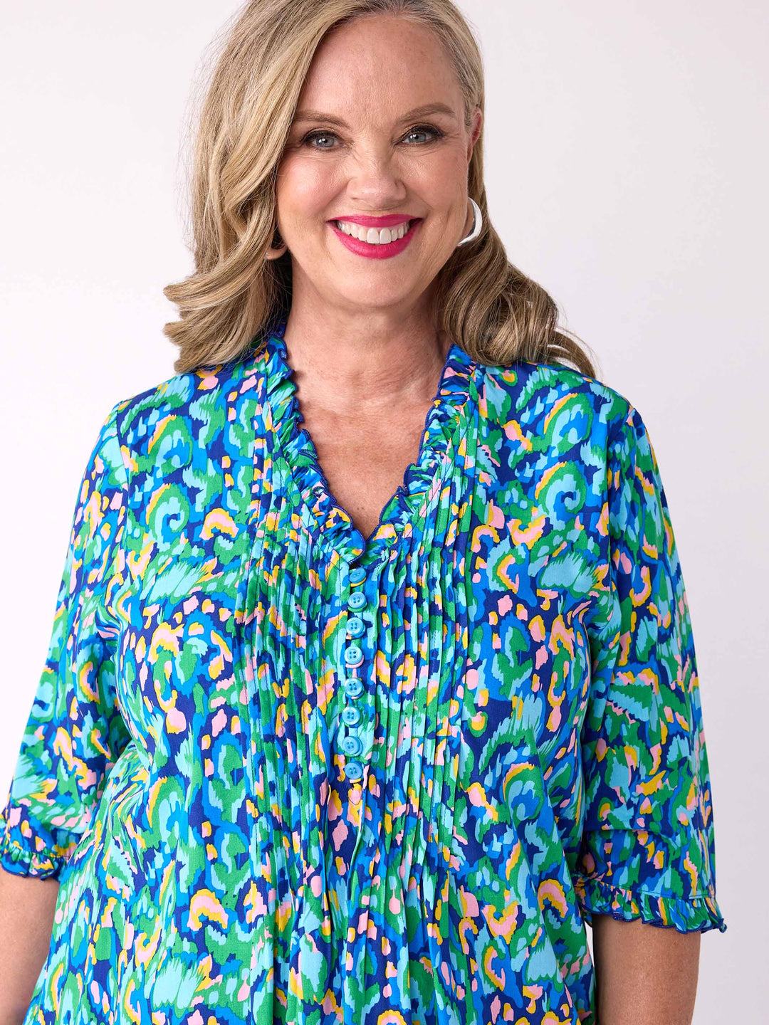 A woman wearing a colourful abstract print tunic top 