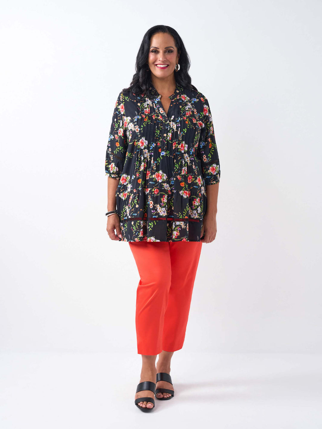 A woman wearing a black floral three-quarter-sleeve button-up top with lace detail