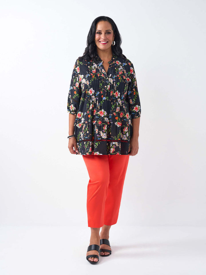 A woman wearing a black floral three-quarter-sleeve button-up top with lace detail
