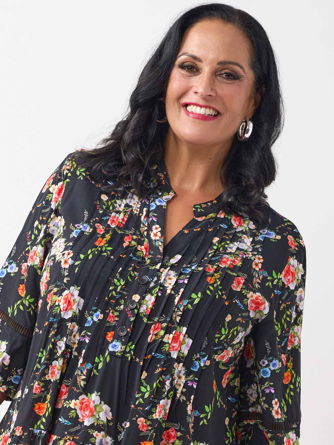 A woman wearing a black floral three-quarter-sleeve button-up top with lace detail