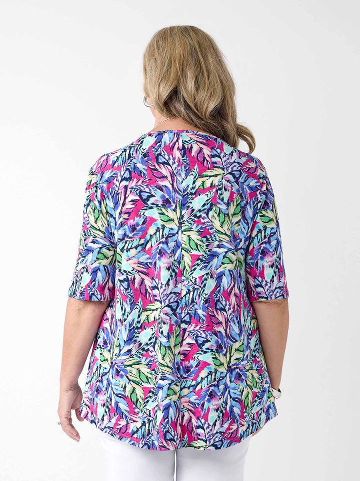 a woman wearing a summer top with vibrant tropical print in navy and pink