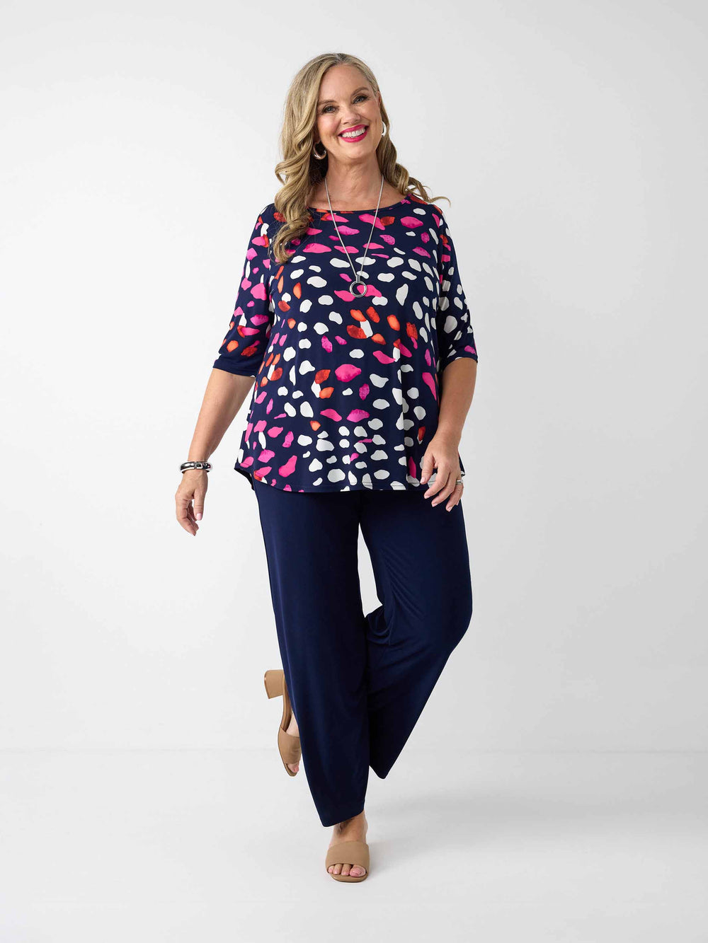 model wearing a navy blue three-quarter sleeve top with a colourful pebble print, paired with navy palazzo pants