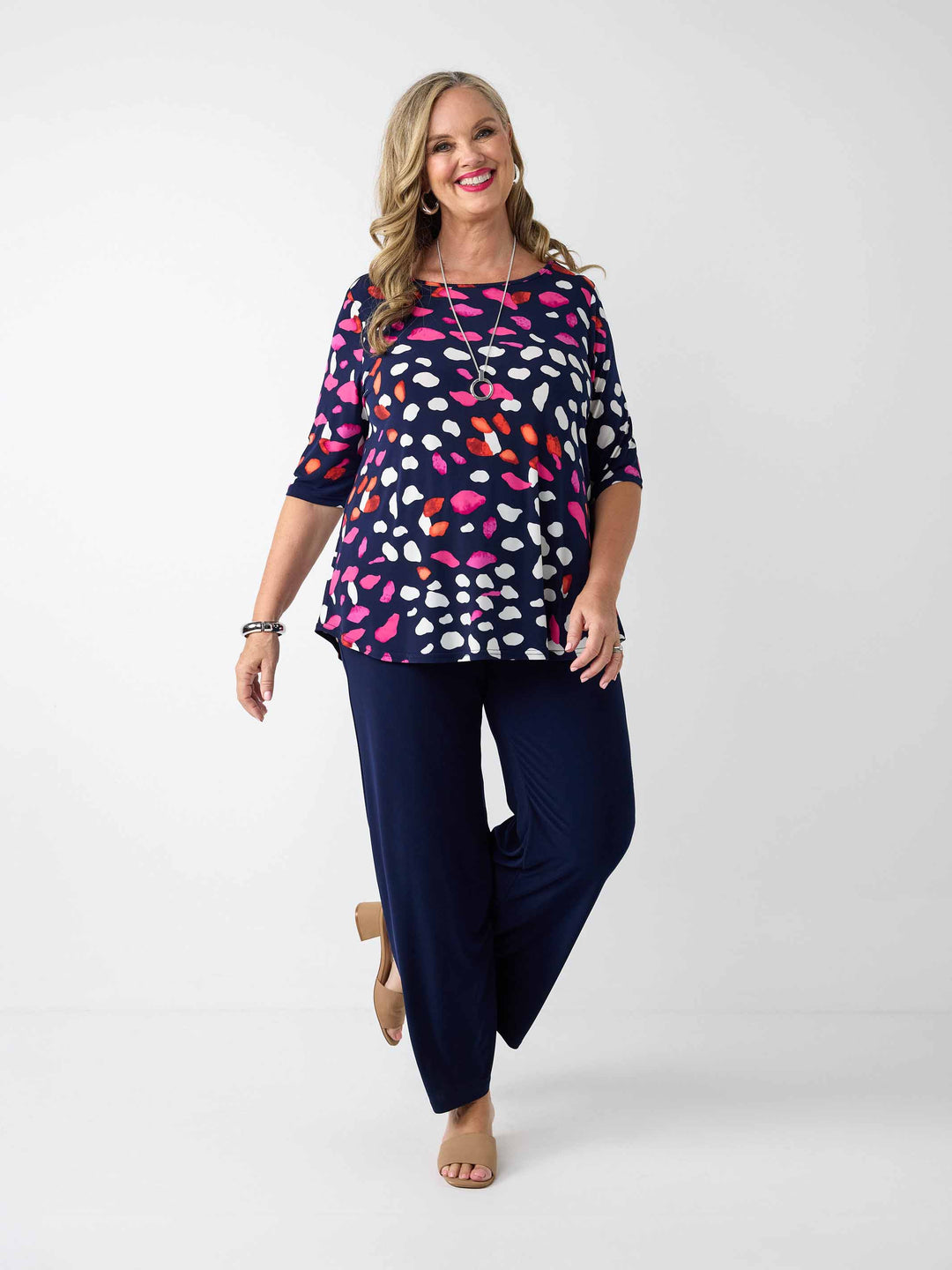 model wearing a navy blue three-quarter sleeve top with a colourful pebble print, paired with navy palazzo pants