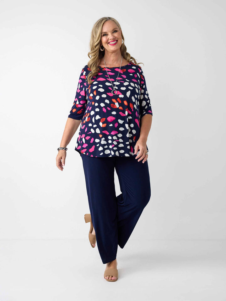 model wearing a navy blue three-quarter sleeve top with a colourful pebble print, paired with navy palazzo pants