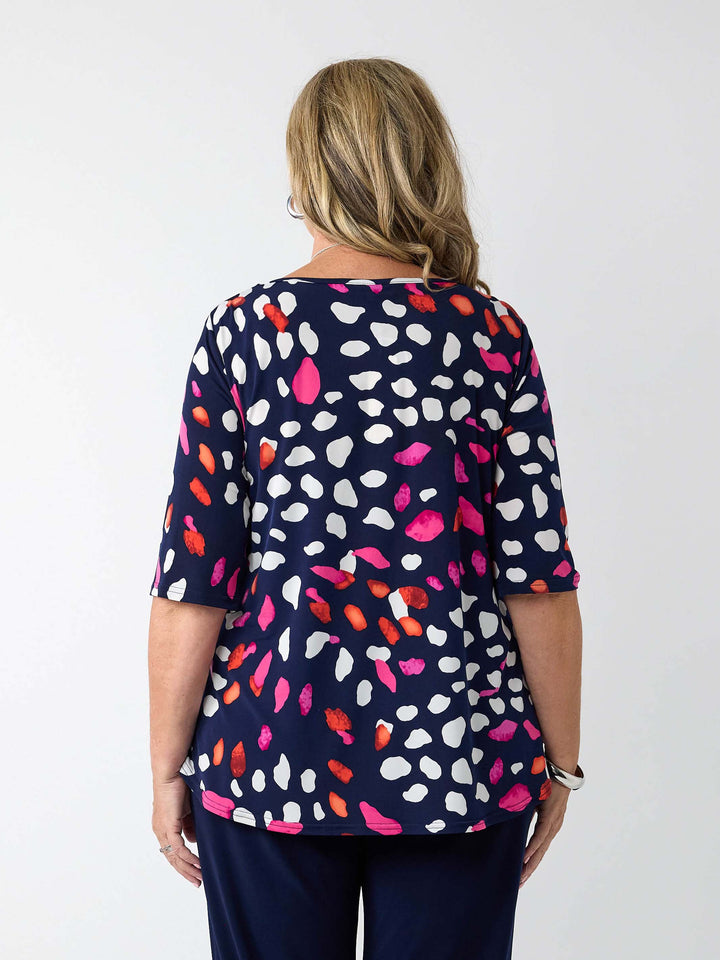 back view of a navy blue top with a colourful pebble print in white, pink and red, paired with navy pants