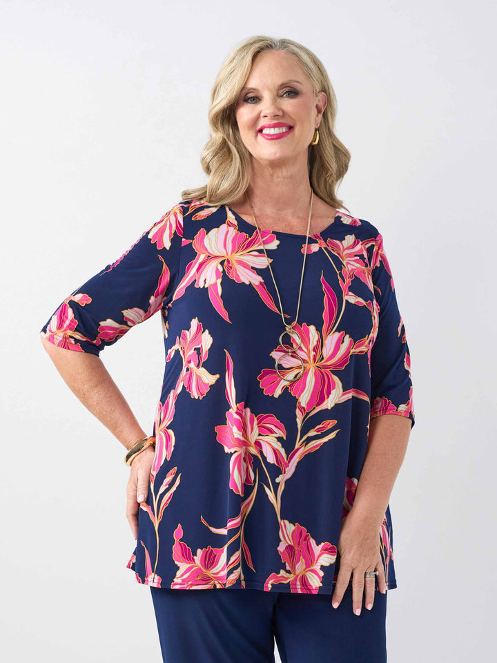 front view of model wearing a navy blue short-sleeve top with a vibrant pink floral print