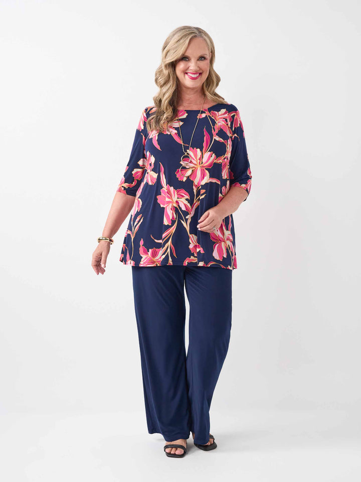 model wearing a navy blue short-sleeve top with a vibrant pink floral print