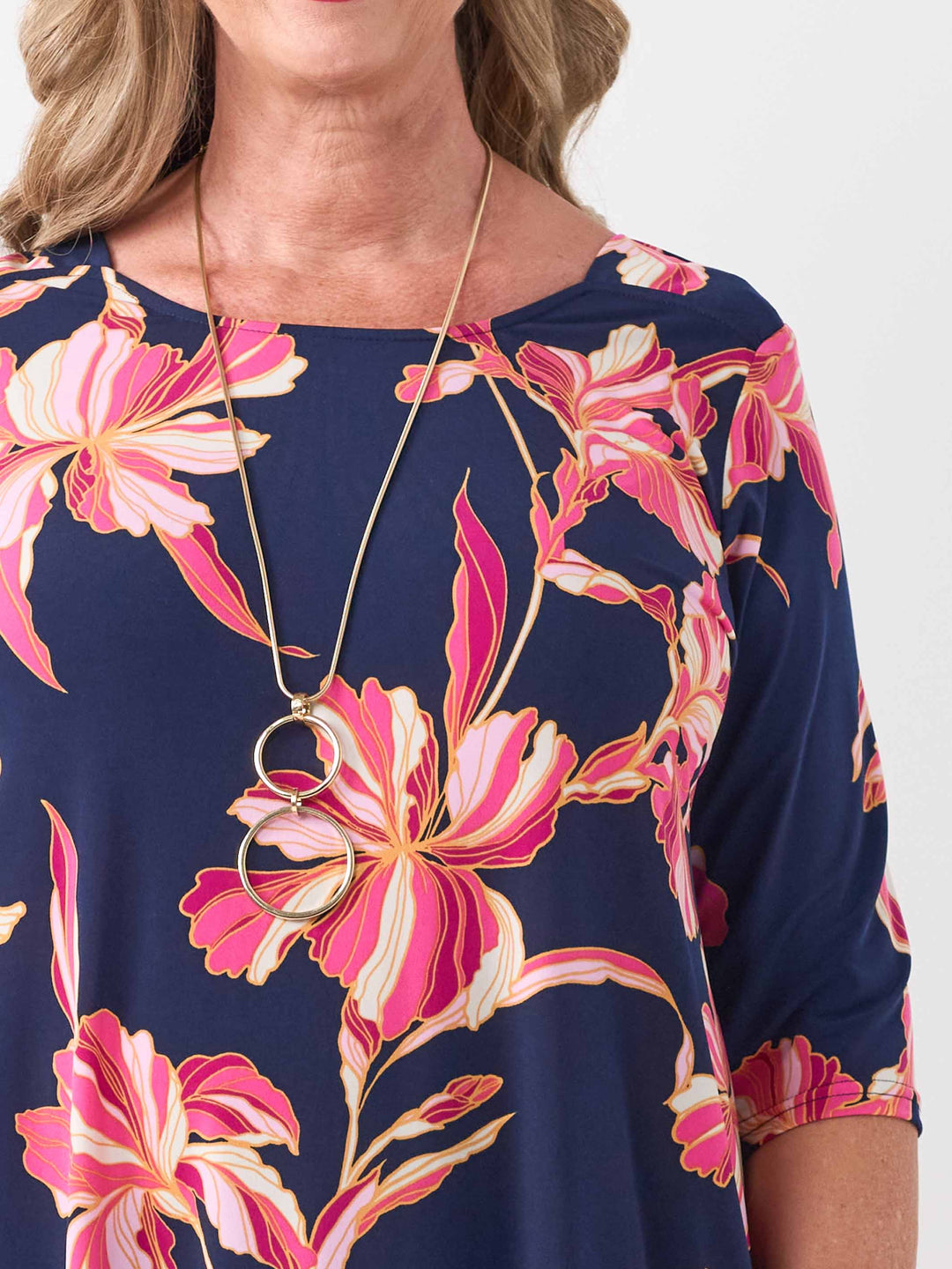 close-up view of model wearing a navy blue short-sleeve top with a vibrant pink floral print