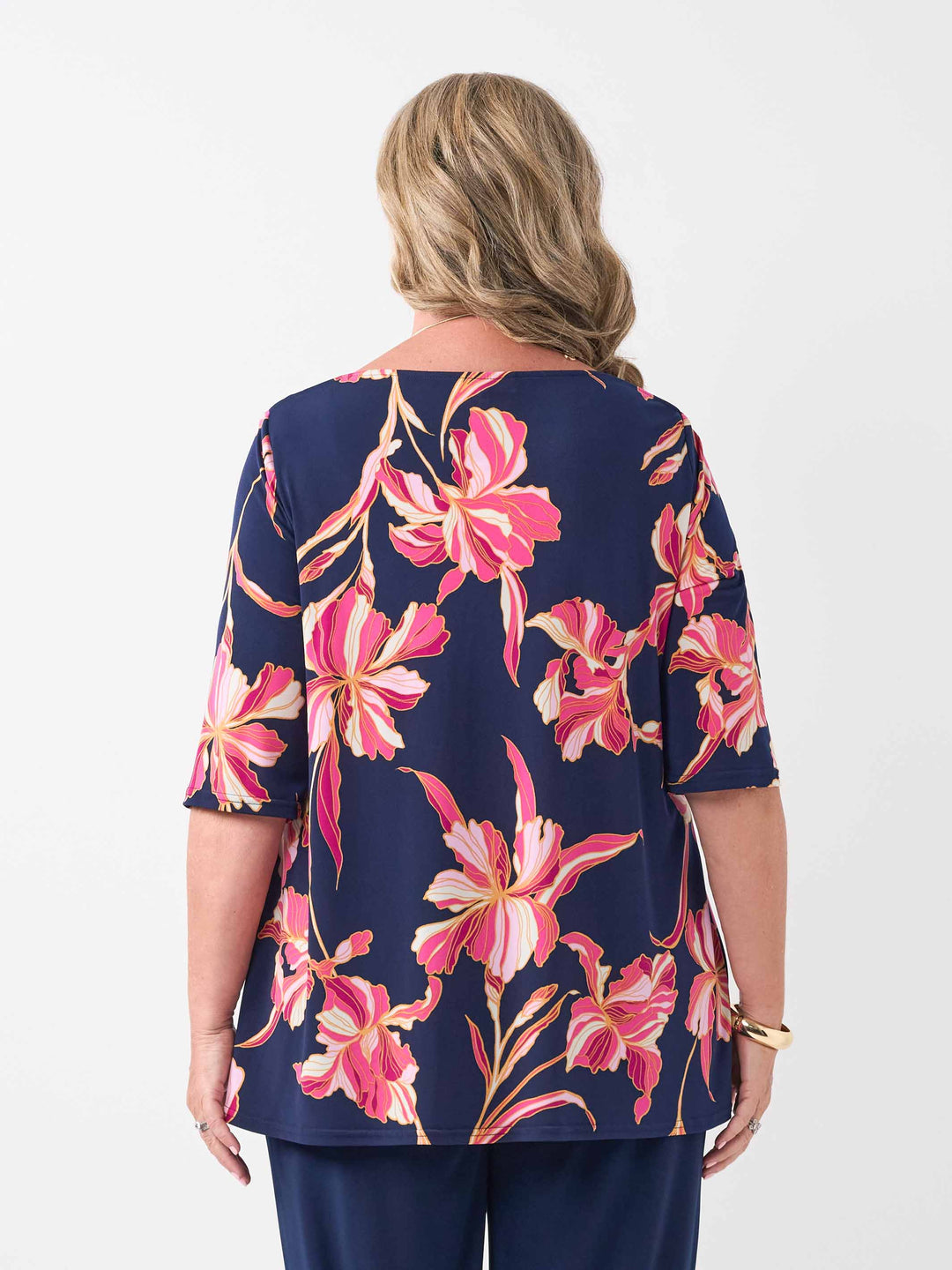 back view of model wearing a navy blue short-sleeve top with a vibrant pink floral print