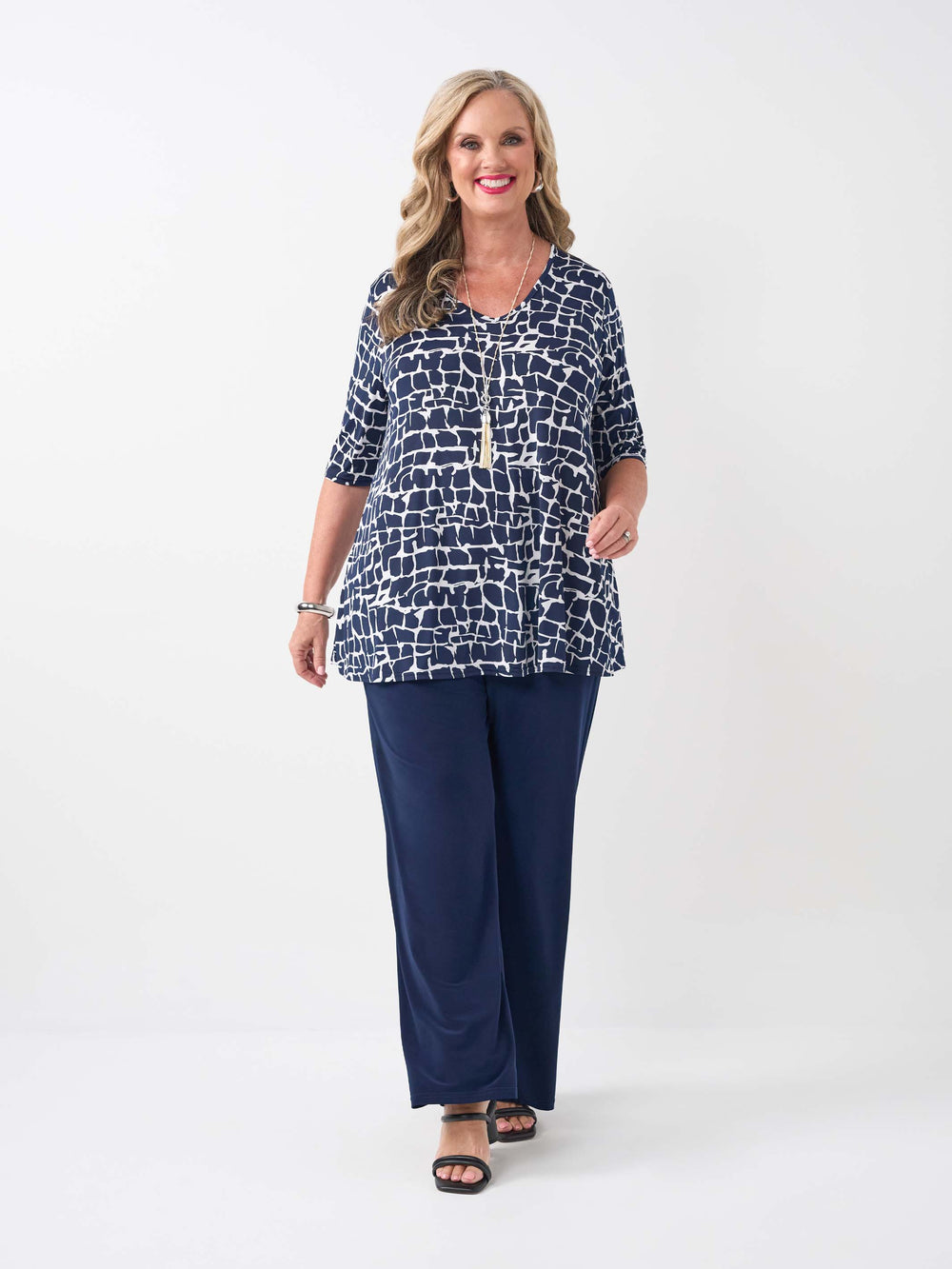model wearing a navy blue and white abstract patterned v-neck swing jersey top with three-quarter sleeves