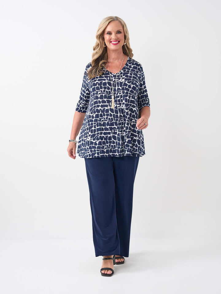 model wearing a navy blue and white abstract patterned v-neck swing jersey top with three-quarter sleeves