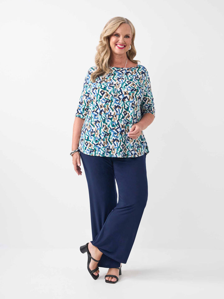 model wearing a three-quarter sleeve top with a colourful abstract geometric pattern
