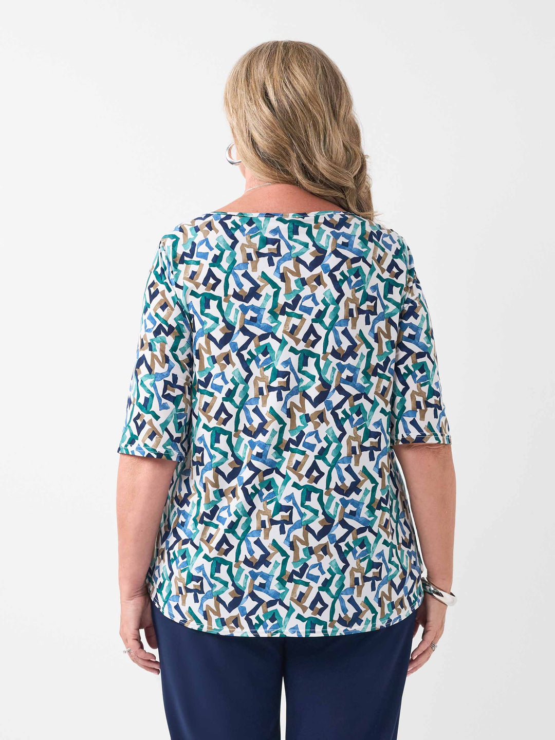 back view of model wearing a three-quarter sleeve top with a colourful abstract geometric pattern