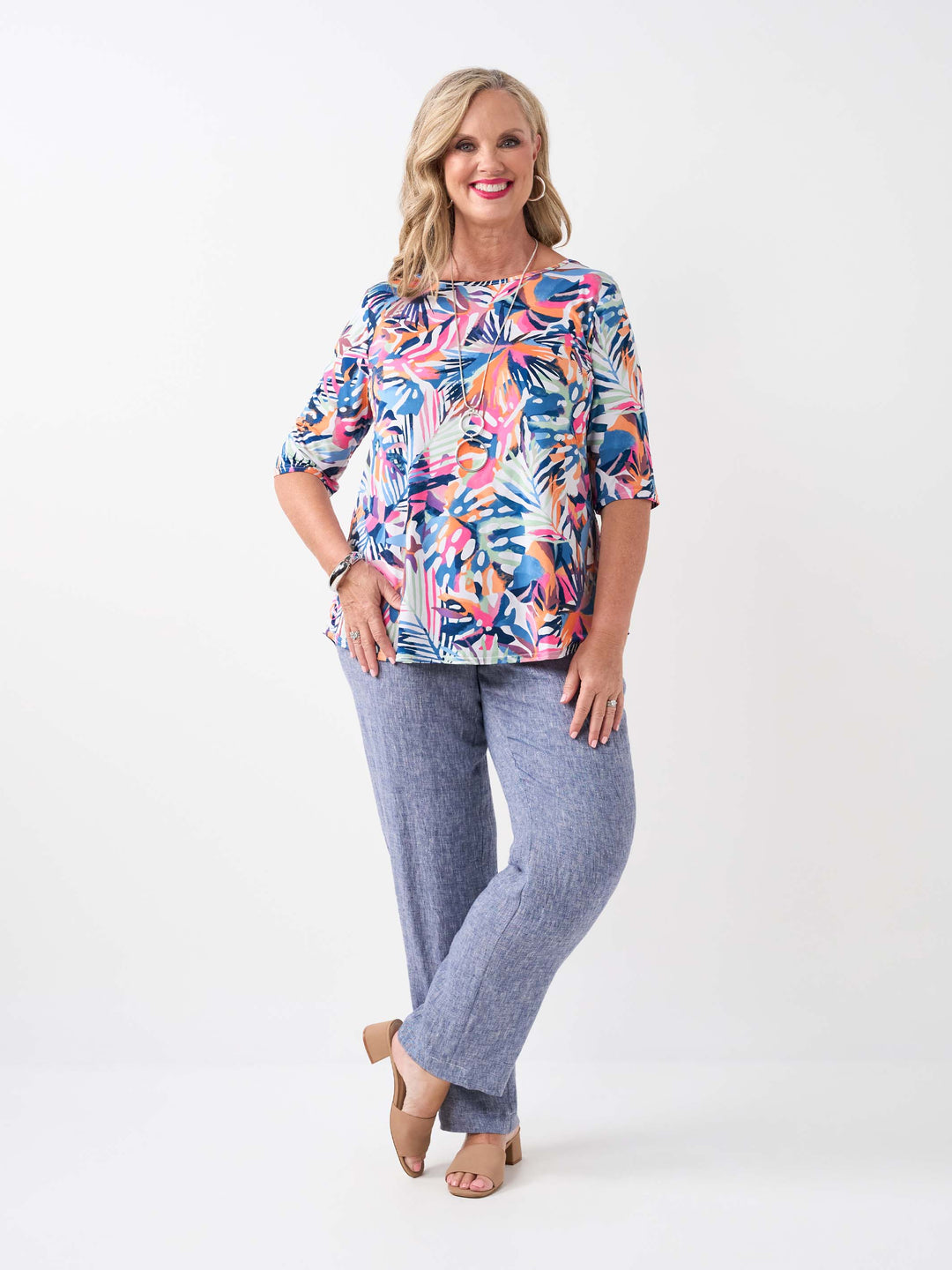 model wearing a colourful tropical print short-sleeve top paired with navy crinkle linen pant