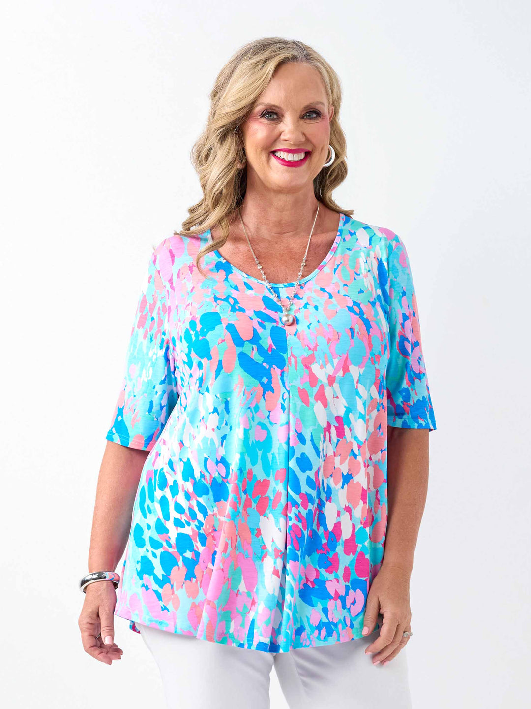 a woman wearing a fresh aqua blue and pink print top with elbow length sleeves and invert pleat