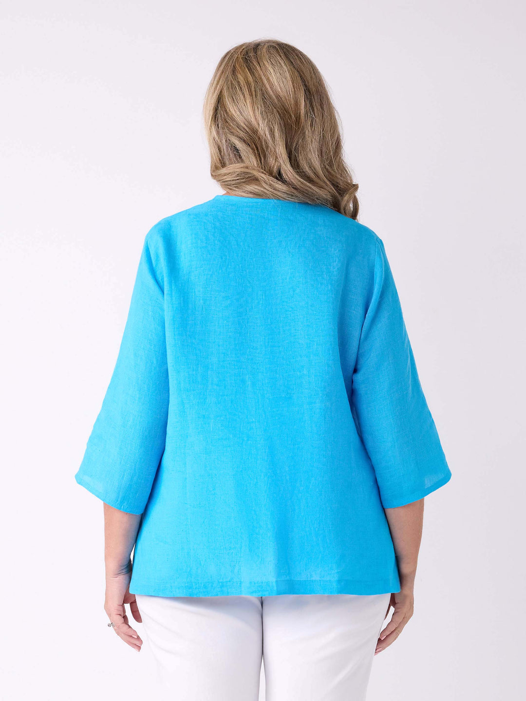 A woman viewed from the back wearing a bright turquoise blue three-quarter sleeve top 