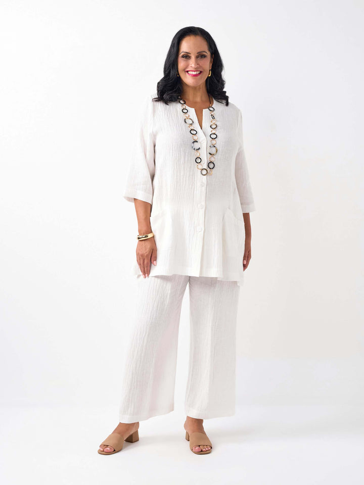 model wearing a white textured crinkle linen button-up top with two front pockets