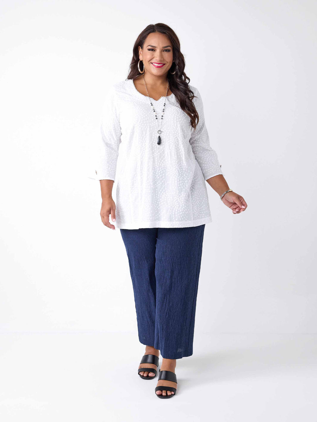 model wearing a white three-quarter sleeves top with a textured, dotted pattern