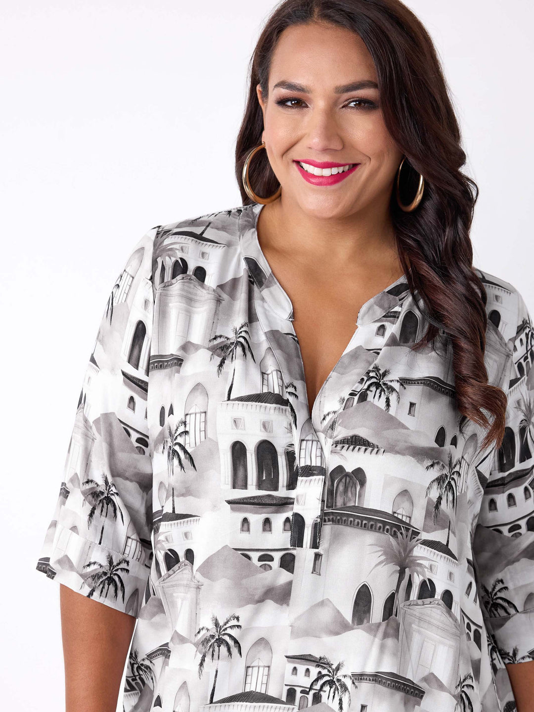 A woman wearing a nehru collared V-neck tunic top with neutral Fez inspired scenic print