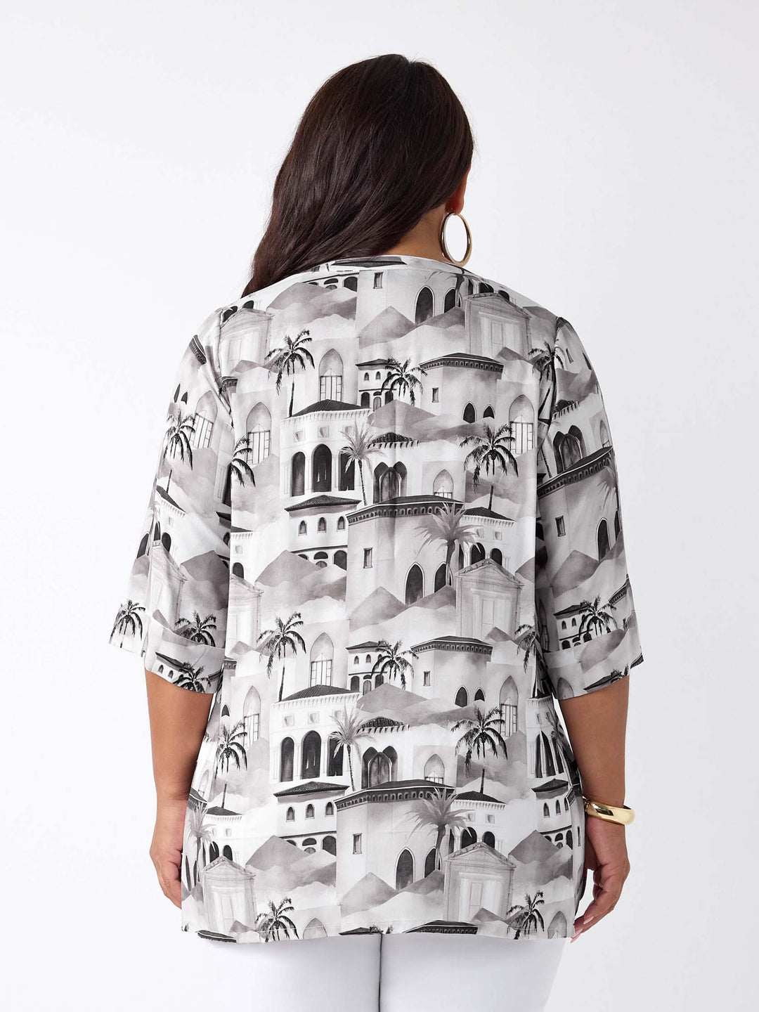 A woman wearing a nehru collared V-neck tunic top with neutral Fez inspired scenic print