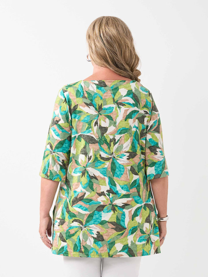 A back view of a woman wearing a green tropical floral print tunic top with three-quarter sleeves