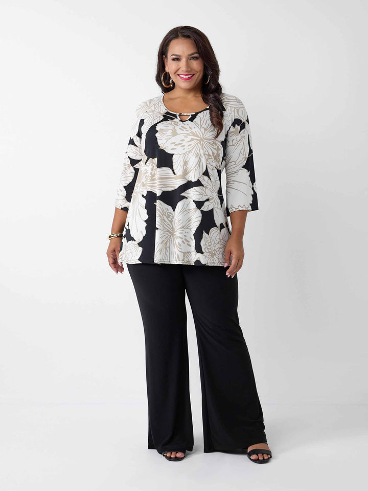 A woman modeling a black and white lotus print top with three-quarter sleeves and a keyhole neckline