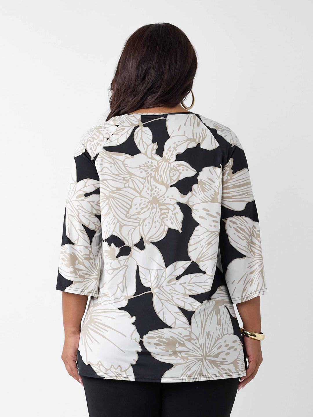 back view of A woman modeling a black and white lotus print top with three-quarter sleeves and a keyhole neckline
