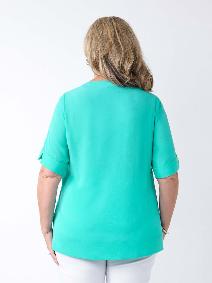 back view of a woman wearing a light mist green bubble textured top
