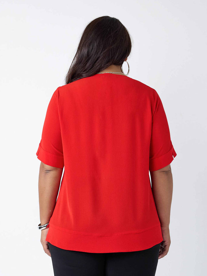 back view of a woman wearing a red round neck bubble textured top