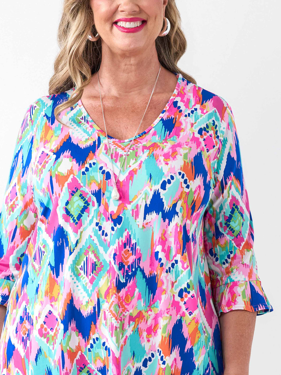 detail view of a woman wearing a v-neck frill sleeve summer top with vibrant and playful print