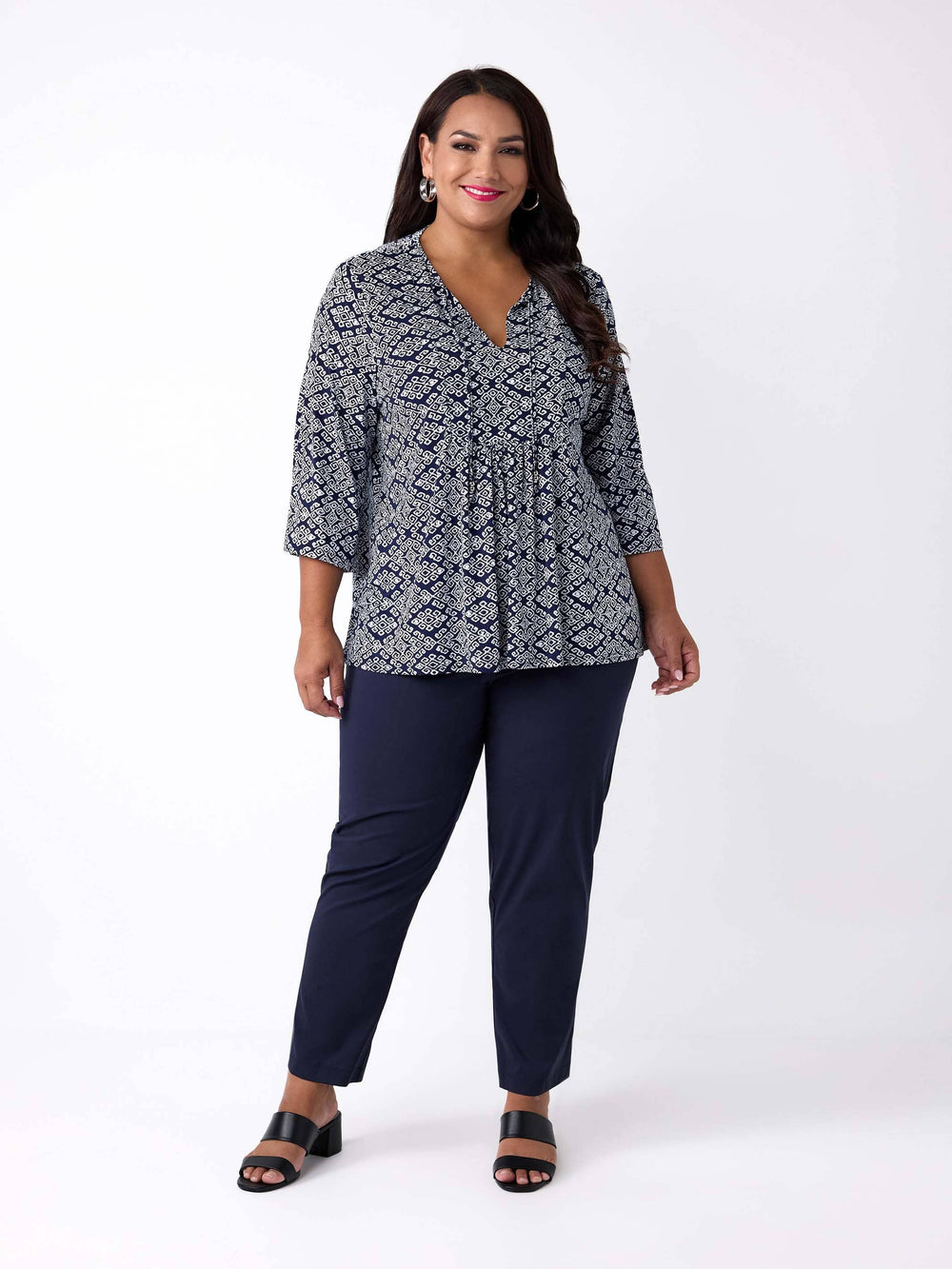A woman wearing a three-quarter sleeve patterned top