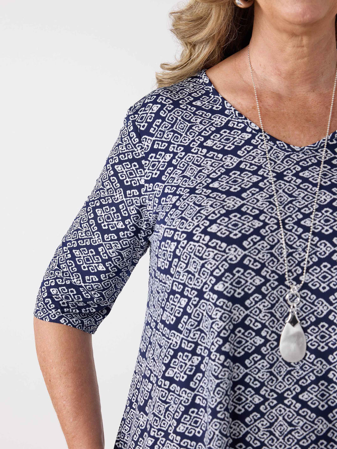 close-up view of a navy v-neck swing jersey top with white print