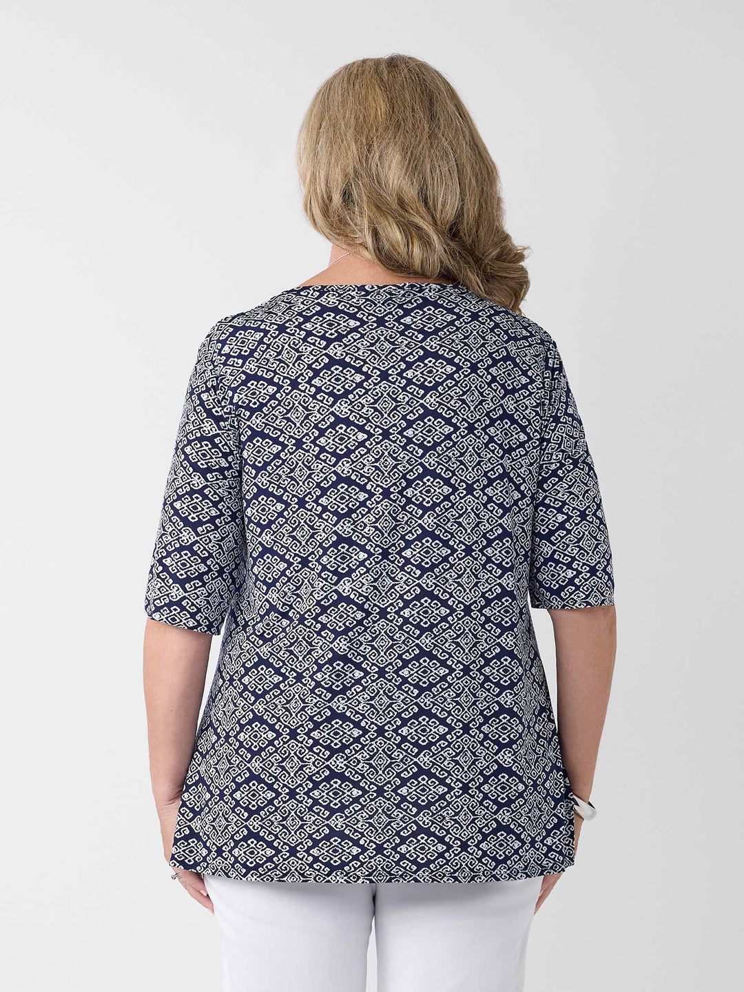 back view of model wearing a navy v-neck swing jersey top with white print