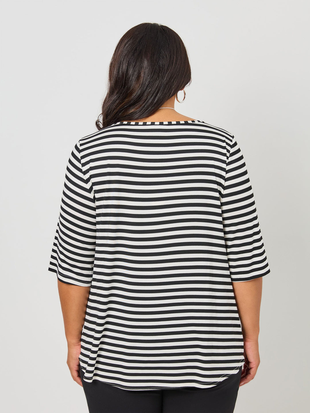 A back view of a woman wearing a black and white striped short-sleeve top with a boat neckline