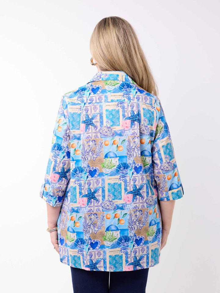 a woman wearing a collared cotton top with blue tropical resort print, featuring a three-quarter sleeves with tab details