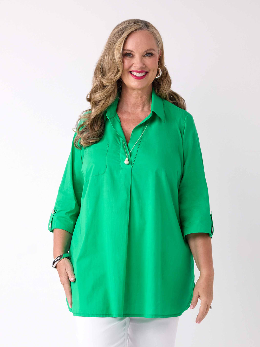 front view of model wearing a bright green collared cotton shirt with three-quarter tab sleeves 