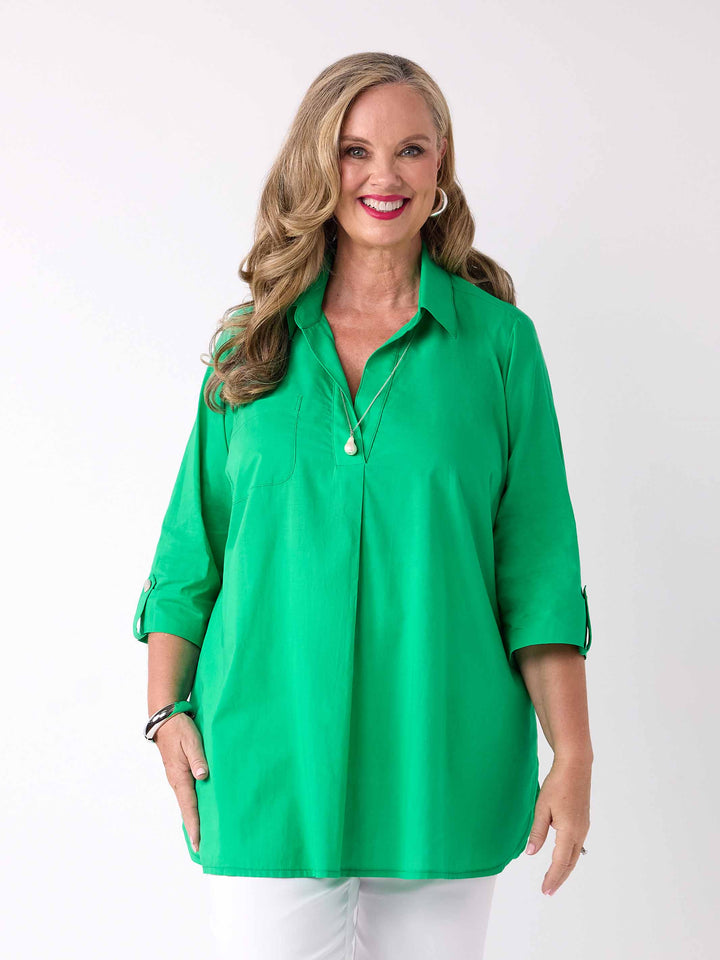 front view of model wearing a bright green collared cotton shirt with three-quarter tab sleeves 
