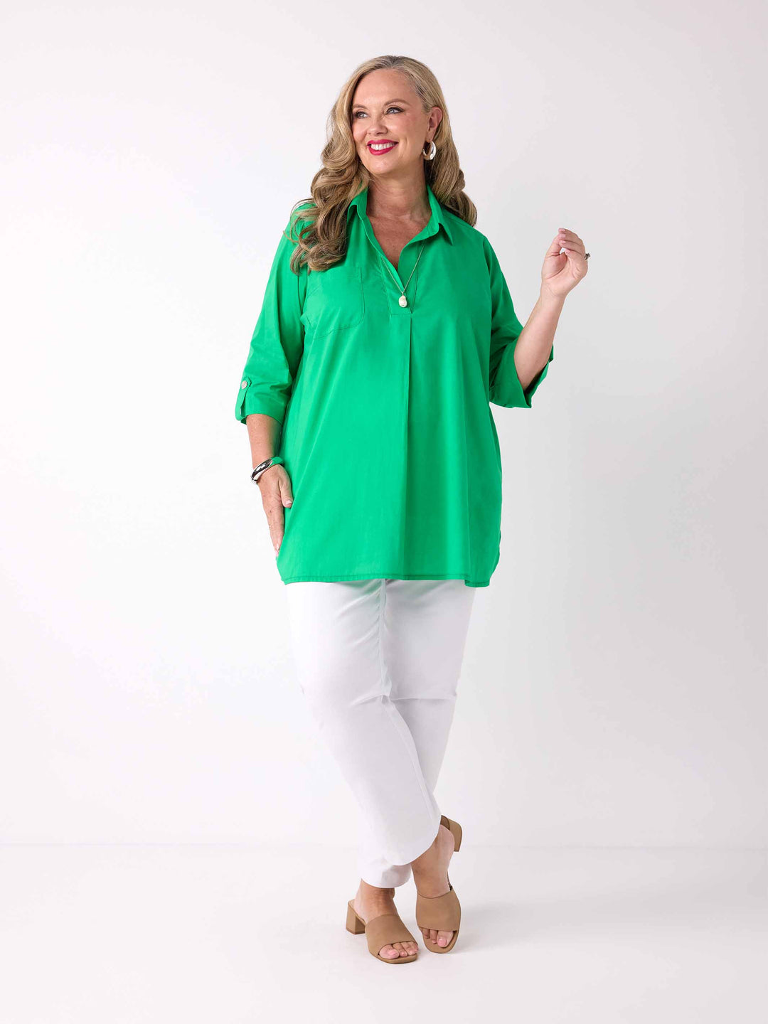 model wearing a bright green collared cotton shirt with three-quarter tab sleeves 