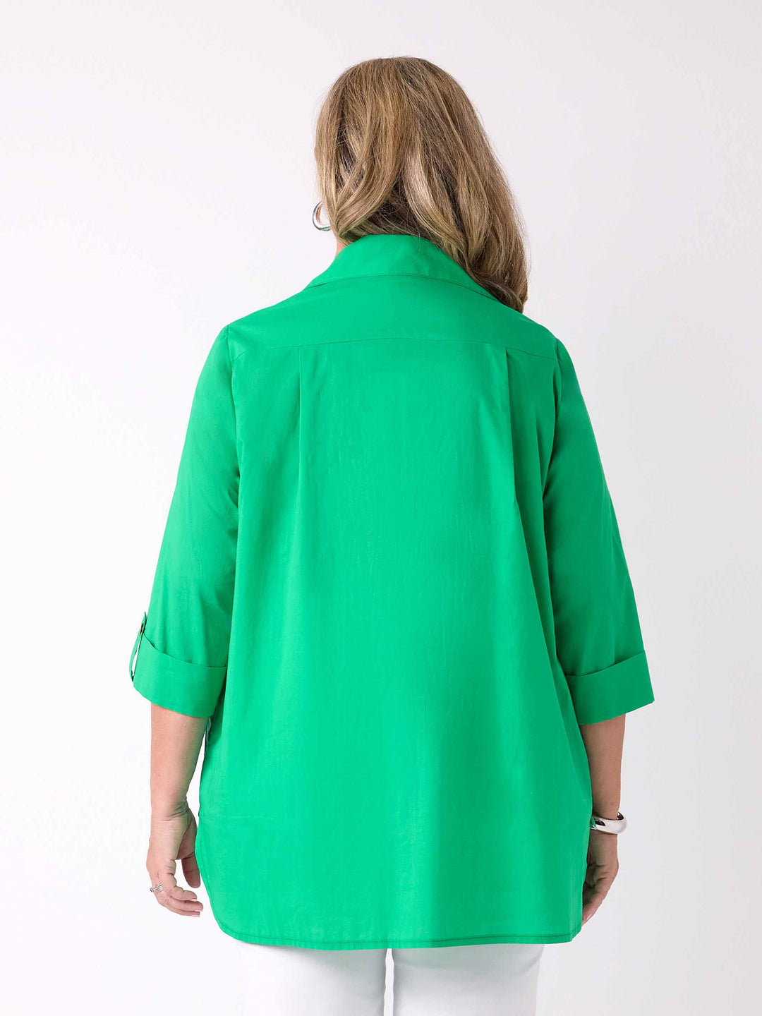 back view of model wearing a bright green collared cotton shirt with three-quarter tab sleeves 