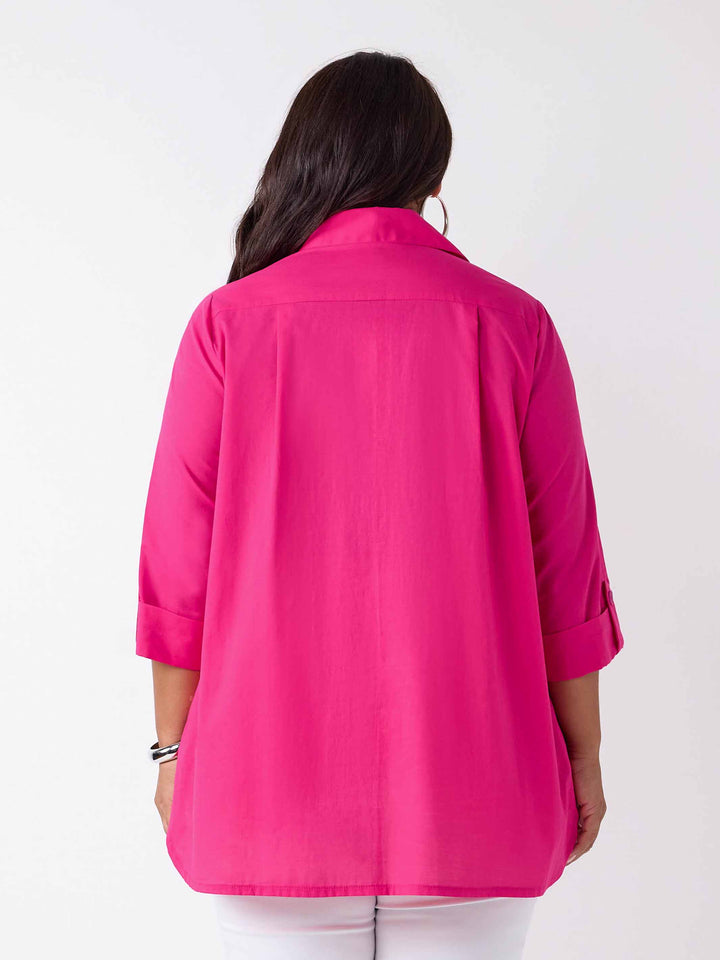 back view of model wearing a bright pink collared top with three-quarter sleeves, paired with white pants