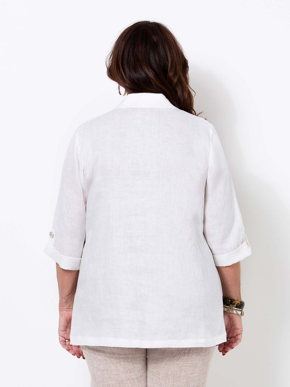 A woman viewed from the back wearing a white linen shirt with three-quarter sleeves 